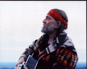 Posterazzi Willie Nelson In Multi Colored Jacket Playing Guitar Photo Print (16 x 20) - Item # MVM54239